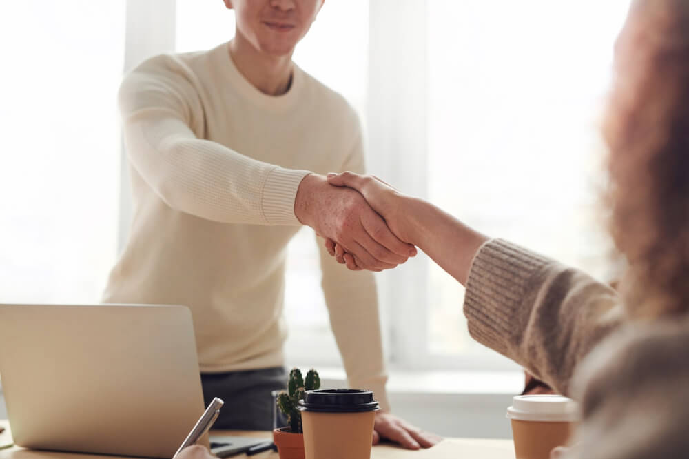 Man and Woman Near Table shaking hands
