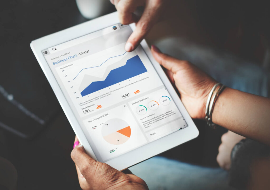 Hands using tablet screen showing statistics business data