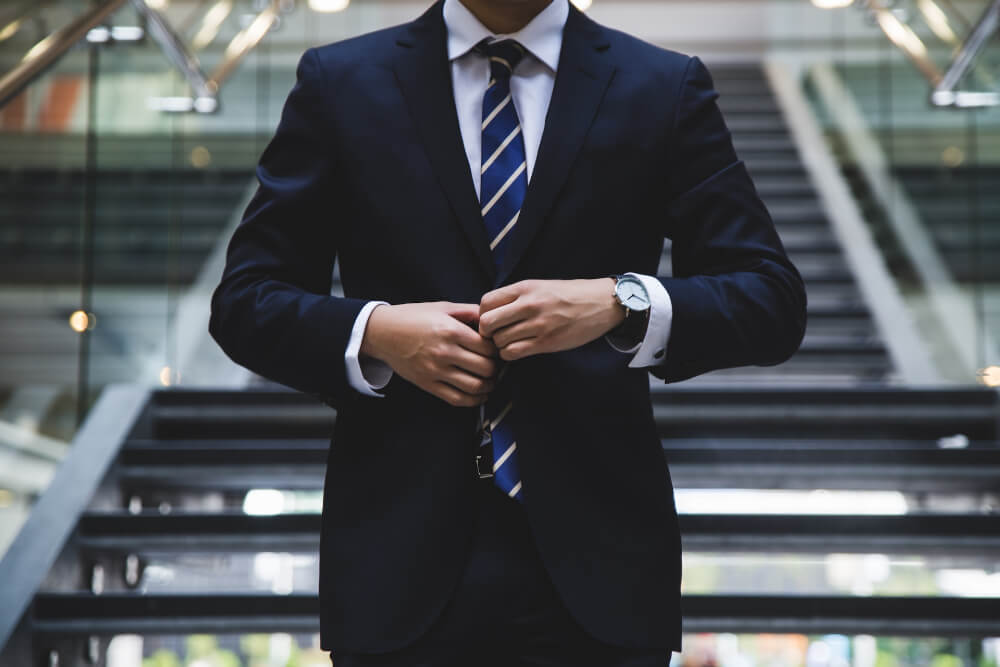 Person in suit standing near the stairs