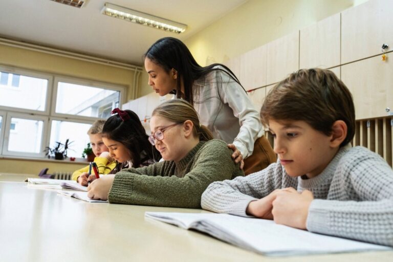Teacher helping students with their work in a classroom