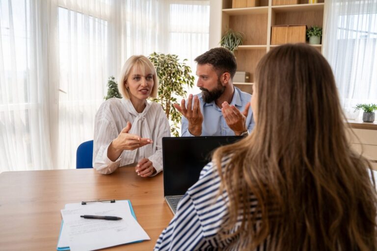 Consultant meeting with two clients at an office table