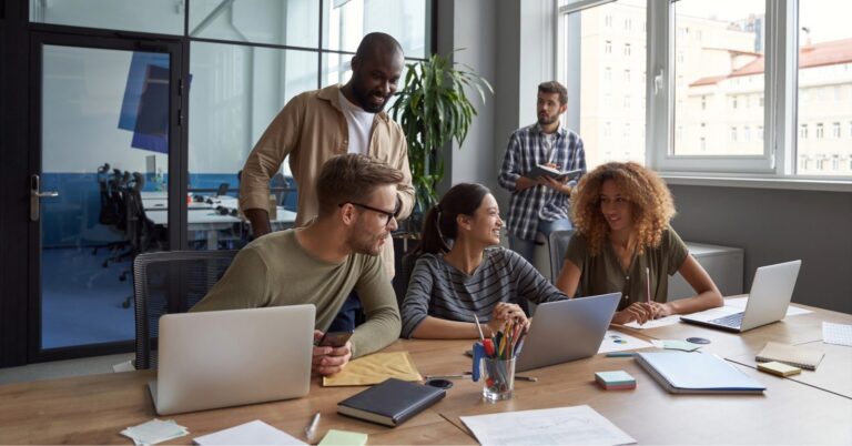 Software team working together at laptops in an office
