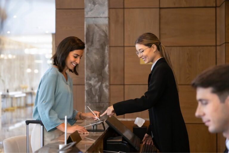 Hotel receptionist helping a guest check in at the front desk
