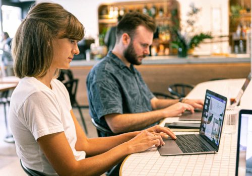 Person typing on a laptop with SEO analytics, keyword research tools, and content strategy notes on the screen, representing SEO-friendly blog writing.